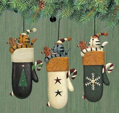 three christmas stockings hanging from a tree with cats and dogs in them, all wearing mittens