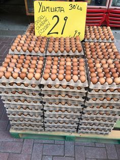 several trays of brown eggs for sale on a street side vendor's stand