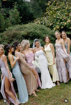 a group of women standing next to each other on top of a lush green field