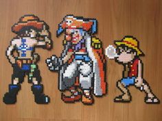 three pixel art pieces are displayed on a wooden surface, one is wearing a cowboy hat and the other has a pirate costume