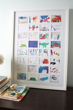 a teddy bear sitting on top of a wooden table next to a white framed photo