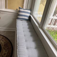 a window seat with a striped pillow on it