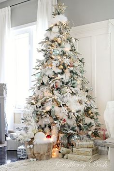 a white christmas tree with gold and silver ornaments