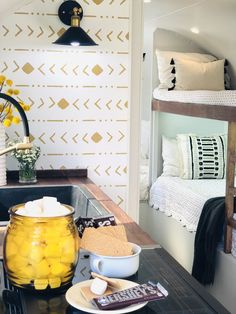 a kitchen area with bunk beds, sink and table