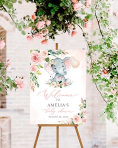 an elephant welcome sign with pink flowers and greenery