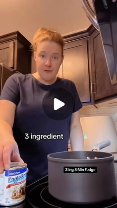 a woman standing in front of a stove with a can of food on top of it