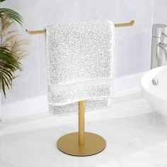 a white towel is hanging on a gold stand