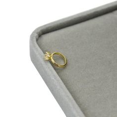 a gold ring sitting on top of a gray cushion