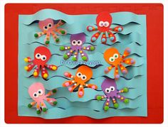 an octopus and other sea animals made out of paper on a blue background with red border