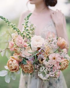 a woman holding a bouquet of flowers in her hands