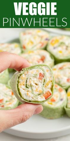 a hand holding a vegetable pinwheels on a plate with the title in the middle