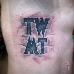 a man's chest with the word wtwm tattooed on it, in black ink