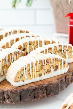 a cake with white icing and cranberries on a wooden platter next to a red cup