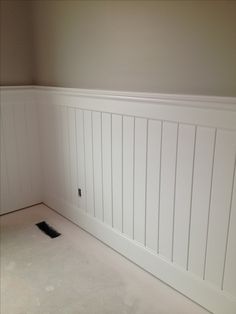 an empty room with white paneling on the walls