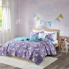 a child's bedroom with pink and purple bedding