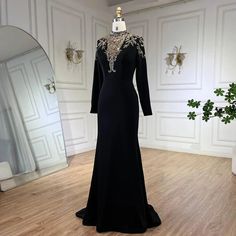 a black evening gown on display in front of a mirror