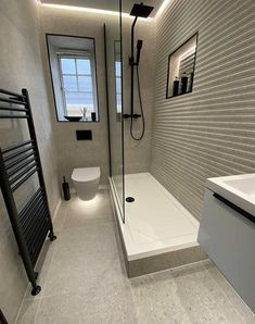 a bathroom with a toilet, sink and shower