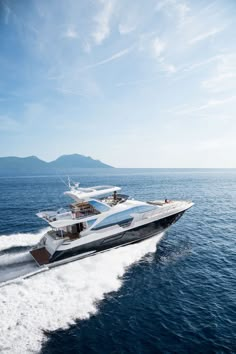 a large white boat in the middle of the ocean with two smaller boats on it's side