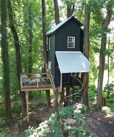 a tree house in the woods with stairs leading up to it