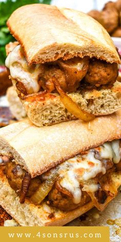 two meatball sub sandwiches stacked on top of each other with cheese and onions in the middle