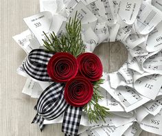 a wreath made out of sheet music with red roses