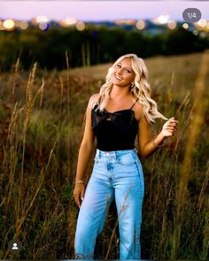 a beautiful blonde woman standing in a field