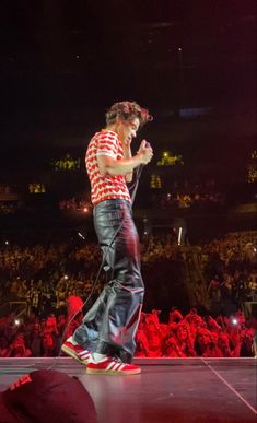 a man standing on top of a stage in front of a crowd