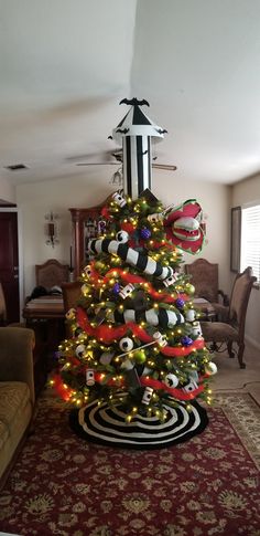 a decorated christmas tree in the middle of a living room with lights and decorations on it