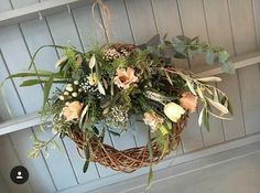 a wicker wreath with flowers hanging from it