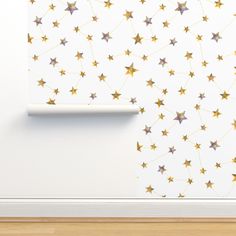 a white wall with gold stars on it and a roll of paper next to it