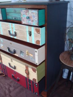 a stack of suitcases sitting on top of a wooden table next to a chair