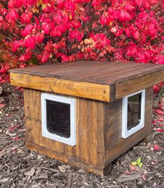 a dog house made out of an old wooden box with two windows on the side