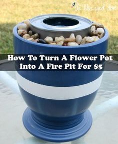 a blue flower pot sitting on top of a table with rocks and gravel in it