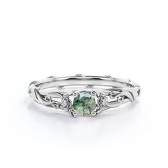 a white gold ring with an oval green tourmaline surrounded by small diamond accents