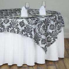 a black and white table cloth with two wine glasses on it, sitting next to each other