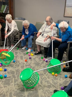 several elderly people playing with plastic balls in a room