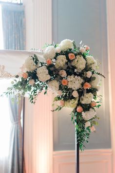 a tall flower arrangement on top of a table