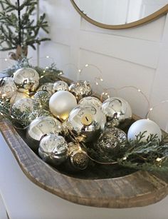 a wooden shelf filled with ornaments on top of a table next to a mirror and christmas tree