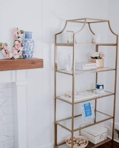 a shelf in the corner of a room with vases and other items on it