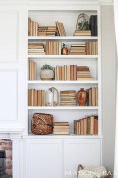 a bookshelf filled with lots of books next to a fire place