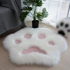 a dog paw rug on the floor next to a potted plant