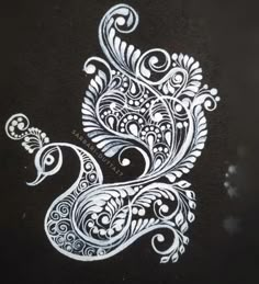 an intricately designed peacock is shown on the ground in white ink and black paper