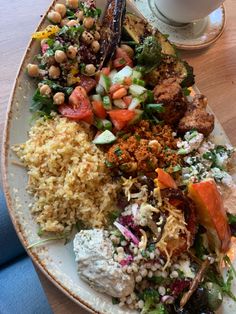 a white plate topped with lots of food next to a cup