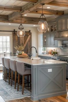 a large kitchen with wooden floors and gray cabinets