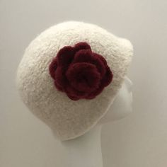 a white hat with a red flower on it