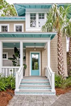 a blue front door and steps leading up to a house with palm trees in the foreground