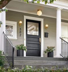 the front door of a house with potted plants