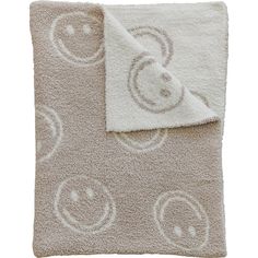 a blanket with smiley faces on it and a white towel in the middle that is folded up