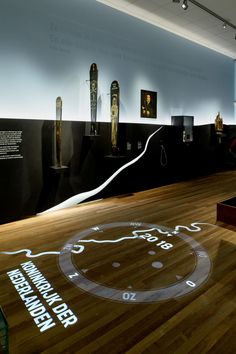 an exhibit room with wooden floors and artwork on the wall