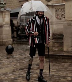 a man with an umbrella standing in the rain